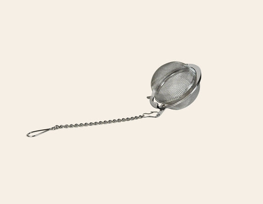 Infuseur à thé type boule avec système de fermeture à clapet sécurisé, garantissant une étanchéité parfaite des feuilles de thé pour une tasse sans résidus.