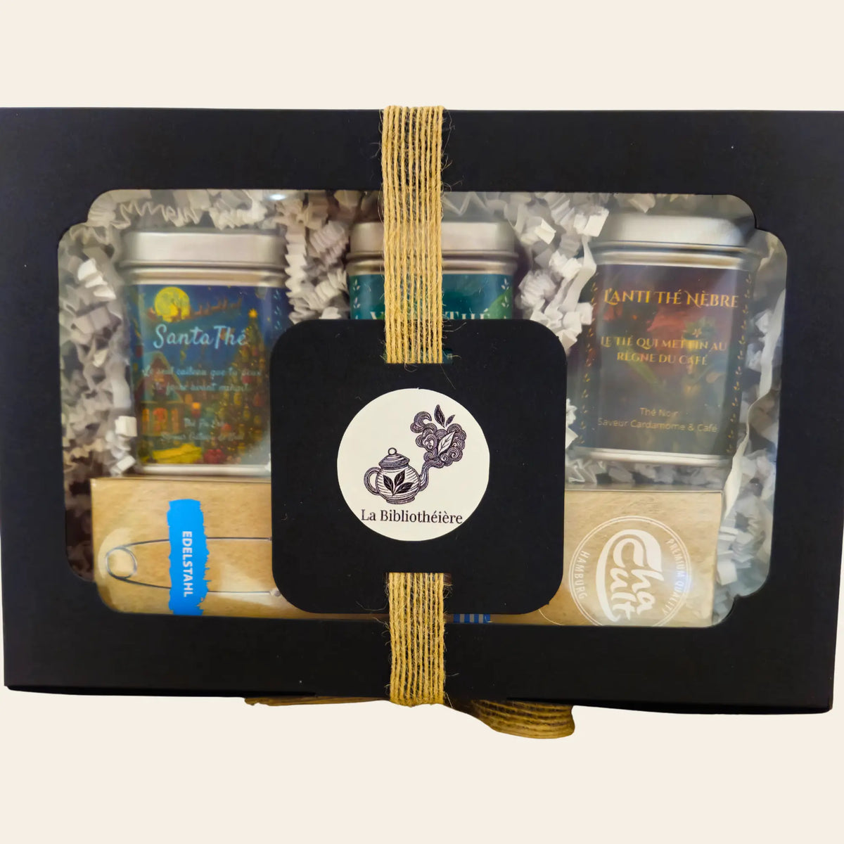 Coffret cadeau La Bibliothéière, gros plan sur la fenêtre, trois thés en vrac et une pince à thé inox