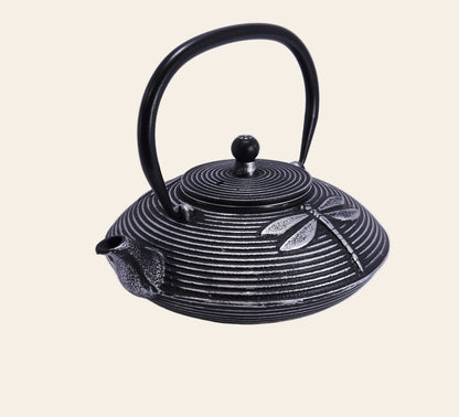 Détail du motif libellule gravé sur le dessus de la théière en fonte noire Lybelle, accessoire de cérémonie du thé esthétique et durable.