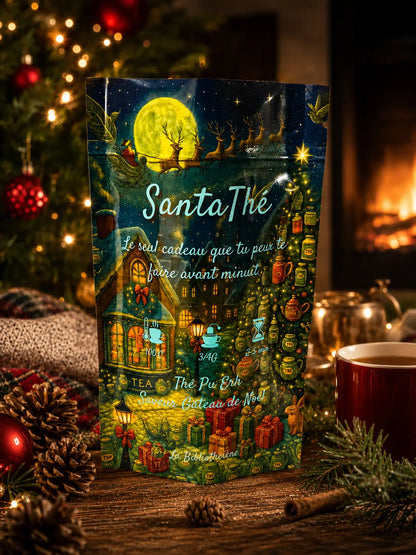Thé noir Pu Erh de Noël Santa Thé de La Bibliothéière, sachet illustré sur un socle doré entouré de sapins illuminés et décorations de fêtes.