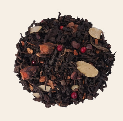 Mélange de thé Pu Erh en vrac avec bâtons de cannelle, éclats de fèves de cacao et amandes effilées pour une infusion de Noël gourmande.